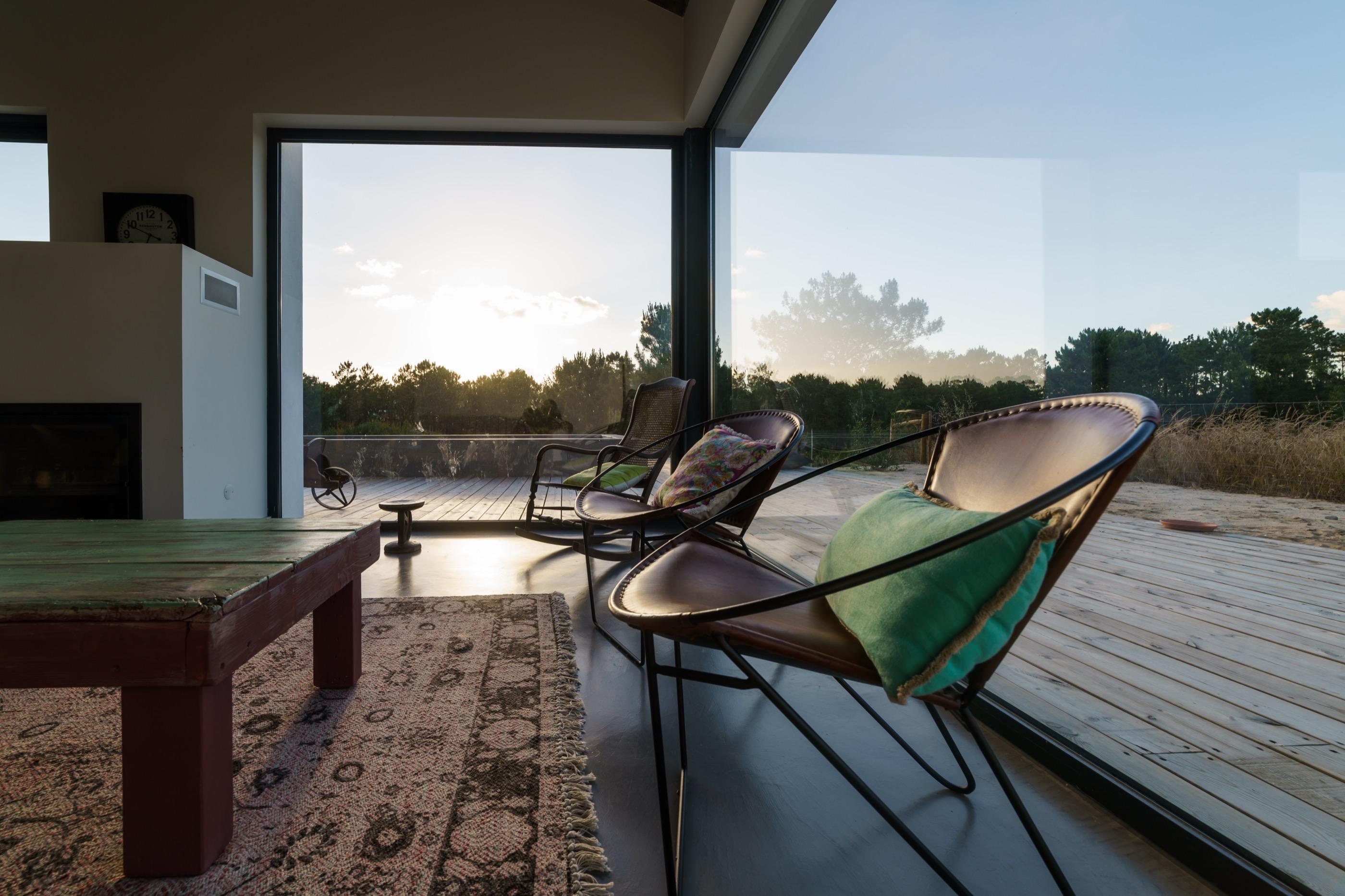 Salón con carpintería de madera vista y cristalera de suelo a techo